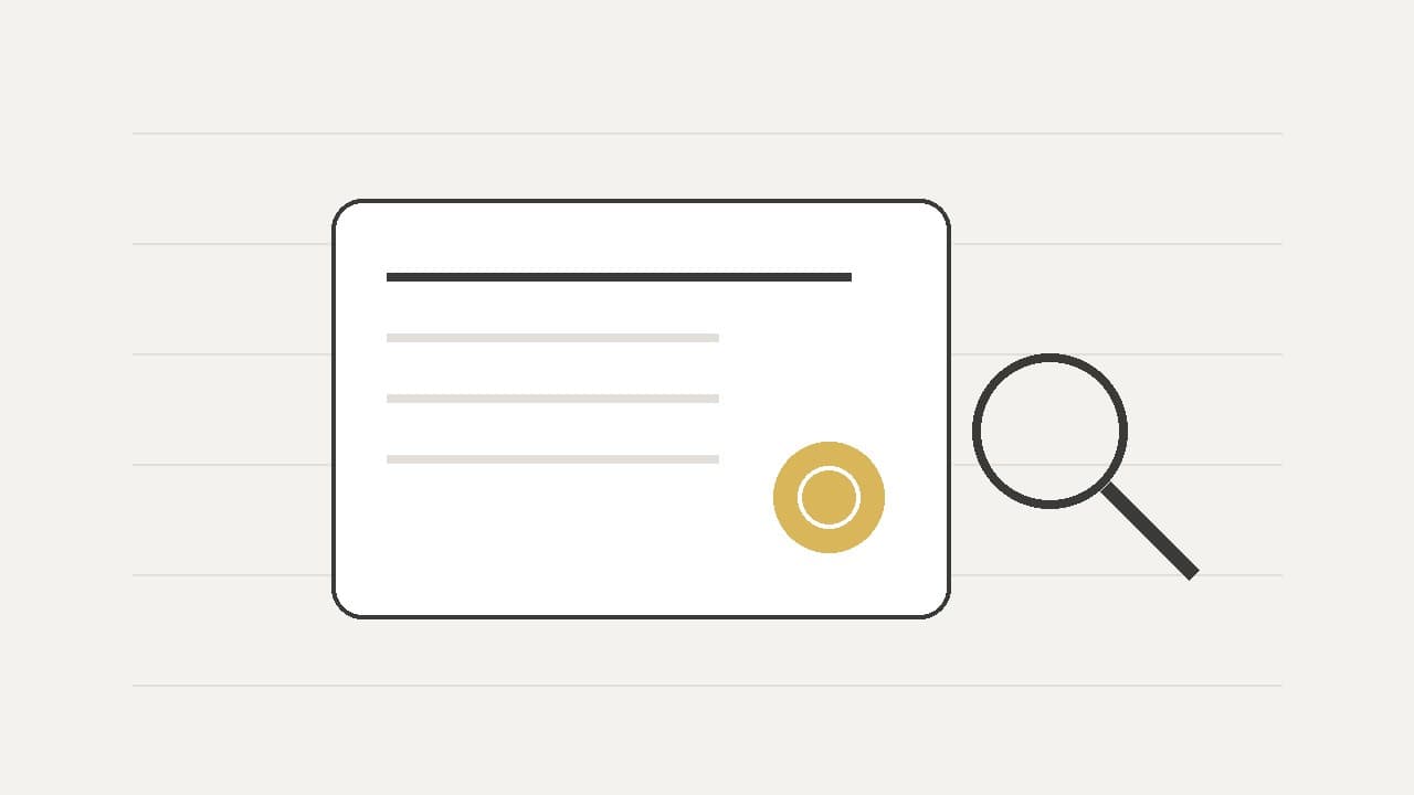 A certificate card with a gold seal, and a magnifying glass beside it